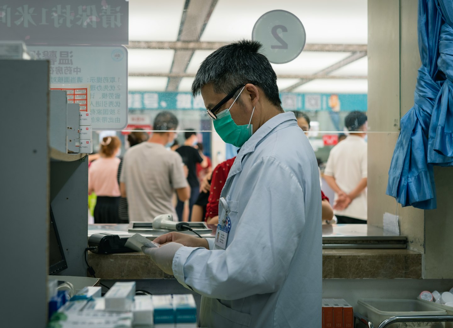 Medical professional reviews documents at a service counter.